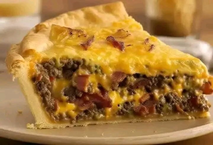 Indulge in a rich and satisfying Bacon Cheeseburger Pie, where all the flavors of a classic cheeseburger are transformed into a comforting, oven-baked delight. Perfect for family dinners or casual gatherings! Ingredients: 1 pre-made pie crust ½ lb ground beef ½ cup cooked bacon, crumbled ½ cup diced onions ½ tsp salt ½ tsp black pepper ½ tsp garlic powder ½ tsp smoked paprika 1 tbsp Worcestershire sauce 1 tbsp ketchup 1 tbsp mustard 1 cup shredded cheddar cheese ½ cup shredded mozzarella cheese ¼ cup heavy cream 1 egg, beaten Instructions: Preheat & Prepare the Crust Preheat your oven to 190°C (375°F). Place the pie crust in a baking dish and pre-bake for 5-7 minutes until lightly set. Cook the Beef Mixture In a skillet over medium heat, cook the ground beef and diced onions until browned. Drain excess fat, then season with salt, black pepper, garlic powder, and smoked paprika. Stir in Worcestershire sauce, ketchup, and mustard, then remove from heat. Prepare the Egg Mixture In a bowl, whisk together the heavy cream and beaten egg. This will create a rich, custard-like texture when baked. Assemble the Pie Sprinkle half of the shredded cheddar and mozzarella cheese over the pre-baked crust. Spread the cooked beef mixture evenly on top. Add the remaining cheese and crumbled bacon over the beef. Pour the egg mixture evenly over the filling. Bake to Perfection Bake for 25-30 minutes or until the cheese is bubbly and the pie is golden brown. Let it Rest & Serve Allow the pie to cool for a few minutes before slicing. Serve warm and enjoy a crispy, cheesy, and savory bite in every slice. 💡 Pro Tip: Customize your pie by addin